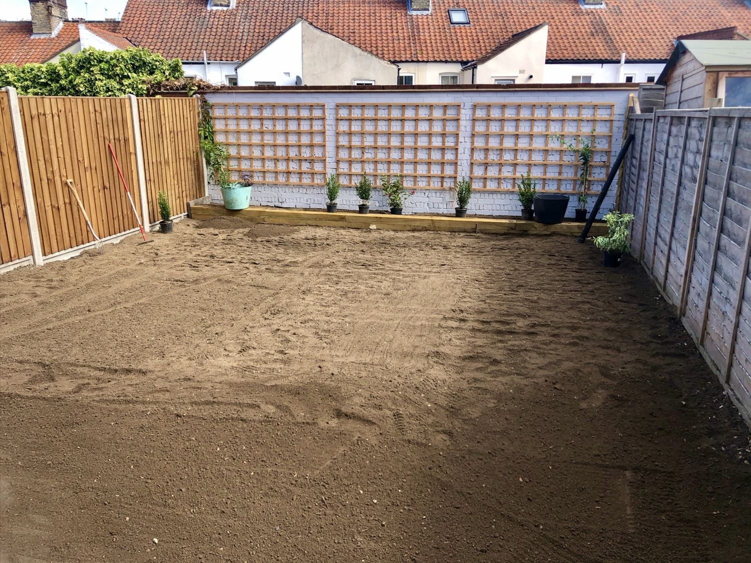 Garden before: levelled bare soil ready for turf, fences and trellis