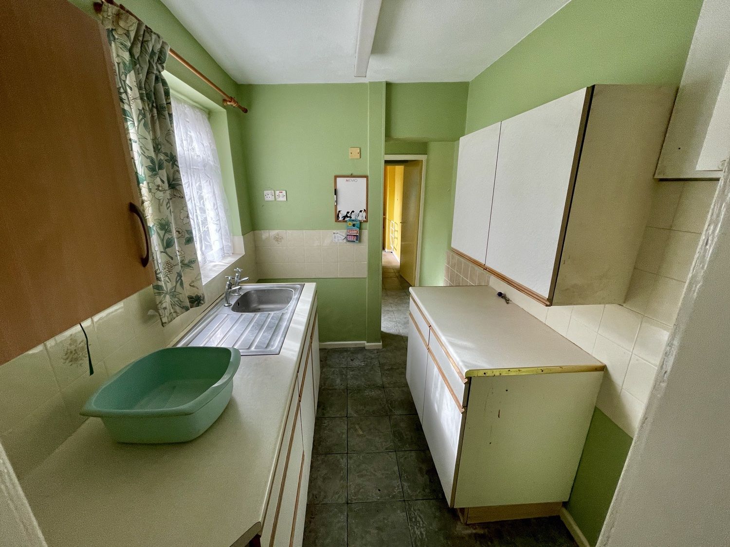Kitchen before the refit: old green galley kitchen with worn units