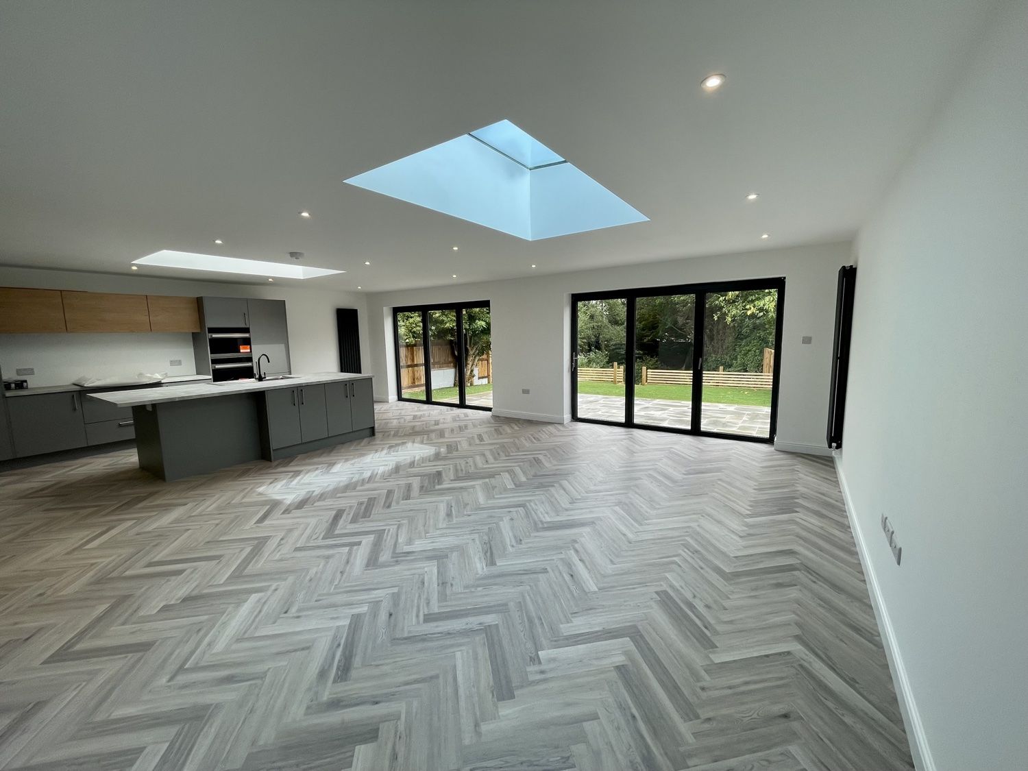 Wide view of the open-plan living space with bifold doors